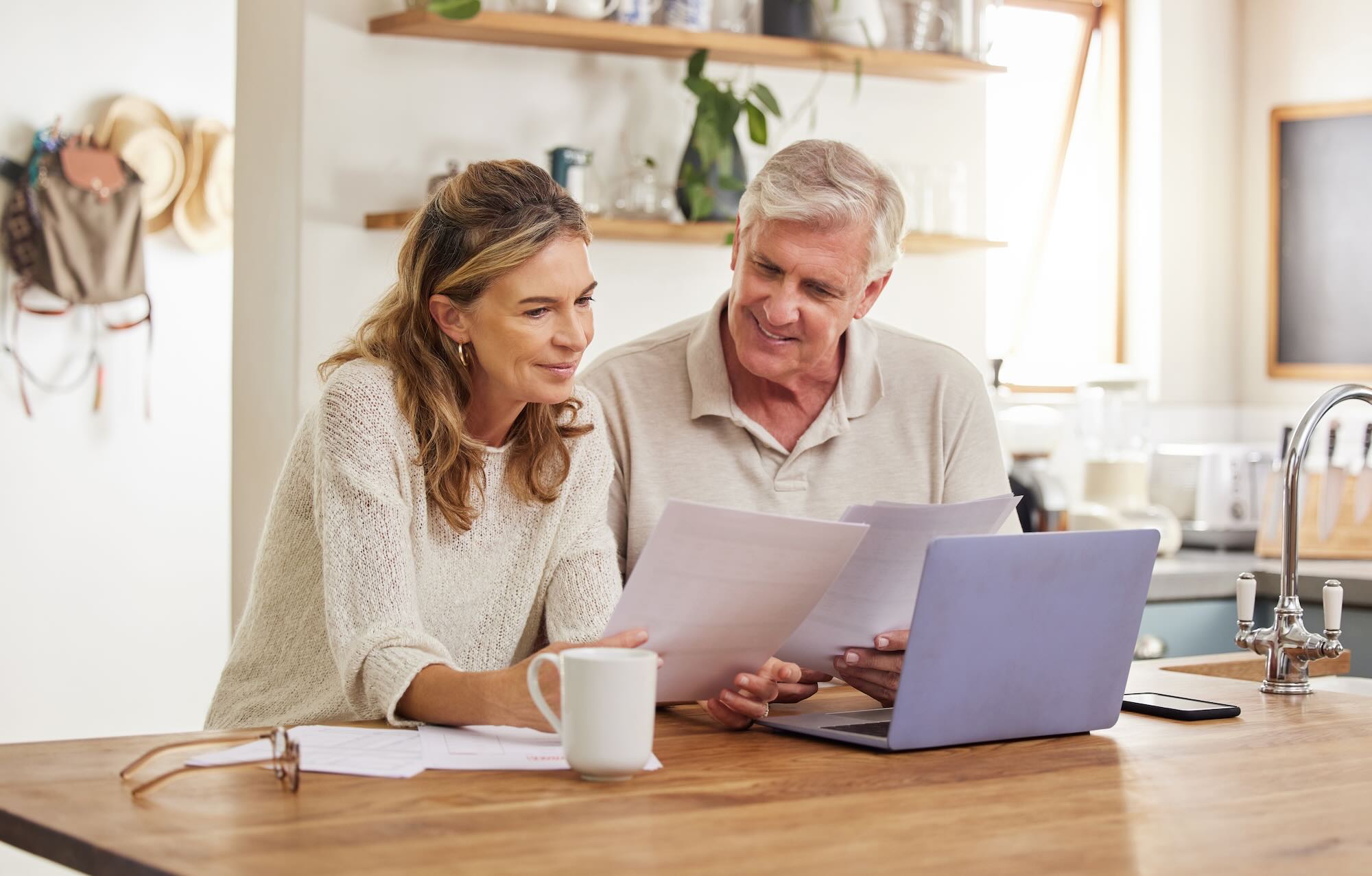 Mature couple going though documents sitting at their kitchen